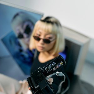 Fashionable Model With Blond Hair Posing With Vintage Electronics In A Studio Setting.