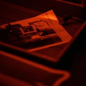 Close Up Of Film Developing Process In A Darkroom Under Red Safelight.