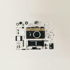 Flat Lay Of Disassembled Vintage Camera Parts Showcasing Intricate Components And Design.