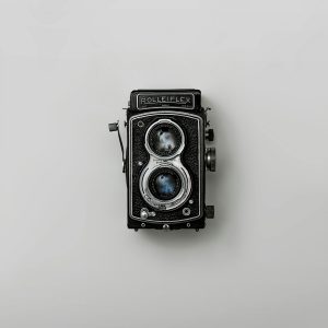Classic Rolleiflex Camera Showcased Against A Simple Background, Emphasizing Nostalgia And Vintage Design.