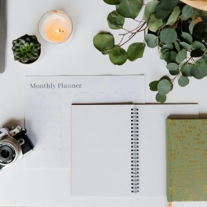 Flat Lay Of A Creative Workspace With A Planner, Analog Camera, And Laptop For Inspiration.