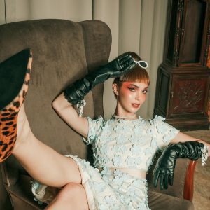 Fashionable Model Posing With Creative Makeup On A Retro Armchair, Showcasing Vintage Vibes.