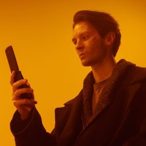 Dramatic Studio Portrait Of A Man Using A Vintage Flip Phone.