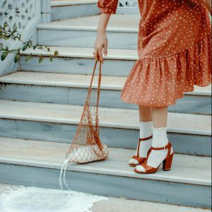Woman In Polka Dot Dress Accidentally Spills Milk While Standing On Stylish Staircase.