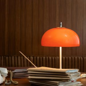 Retro Office Setting With A Red Lamp And Stacked Folders On A Wooden Desk, Capturing A Vintage Vibe.