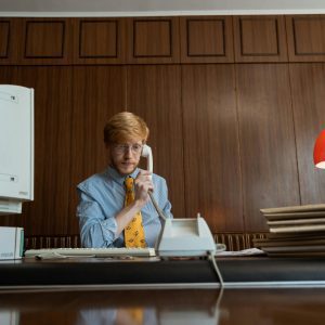 Vintage Office Setting With A Businessman Using A Telephone, Capturing A Nostalgic 1980s Vibe.