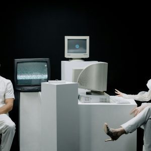 A Modern Depiction With Vintage Computers And Individuals In A Futuristic Lab Setting.
