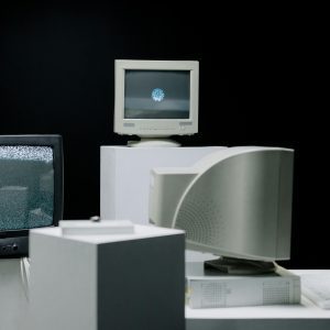 Vintage Computer Monitors Arranged In A Minimalist Setup With A Dark Background, Showcasing Technology Evolution.