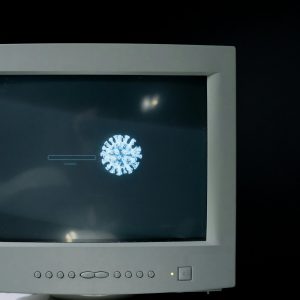 Retro Computer Monitor Showing A Virus Symbol Loading On The Screen.