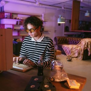 Teen Enjoying A Vintage Gaming Experience Indoors, Highlighting Nostalgia And Retro Vibes.