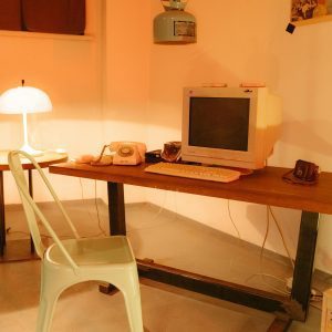 A Cozy Vintage Home Office Featuring A Retro Computer And Warm Lighting