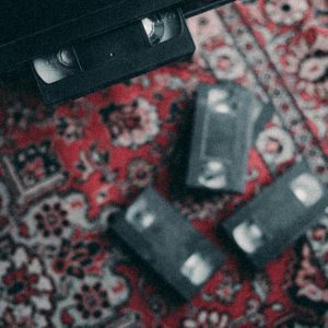 From Above Of Collection Of Similar Vintage Cassettes In Video Recorder And On Colorful Retro Carpet