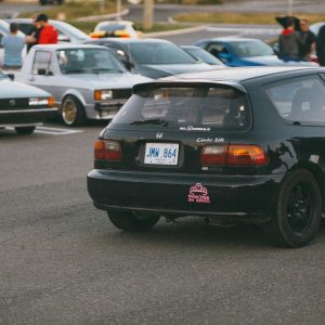 Outdoor Car Meet Showcasing A Classic Honda Civic Surrounded By Other Modified Cars And Enthusiasts.
