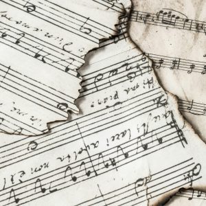 Close Up Of Aged, Burnt Music Sheets Displaying Musical Notes And Compositions In Detail.
