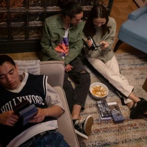 Teenagers Relax Indoors For A Nostalgic Movie Night With Chips And VHS Tapes.