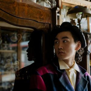 Stylish Young Man In Vintage Setting With Antiques, Reflecting Thoughtful Mood.