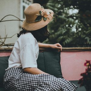 A Woman Wearing A Floral Hat Enjoys Leisure Time On A Hanoi Balcony, Vietnam.